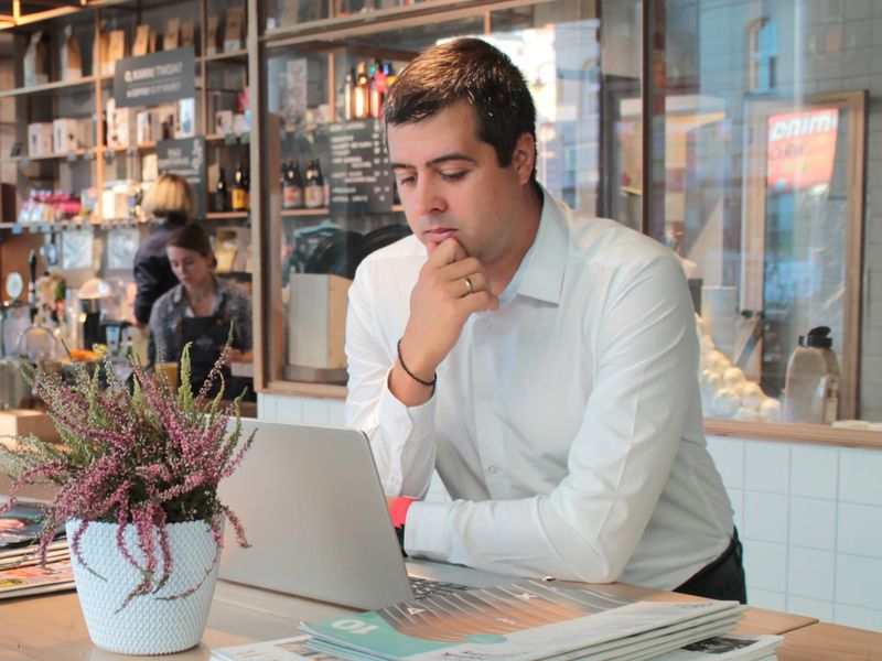 A man working on a laptop at a café counter